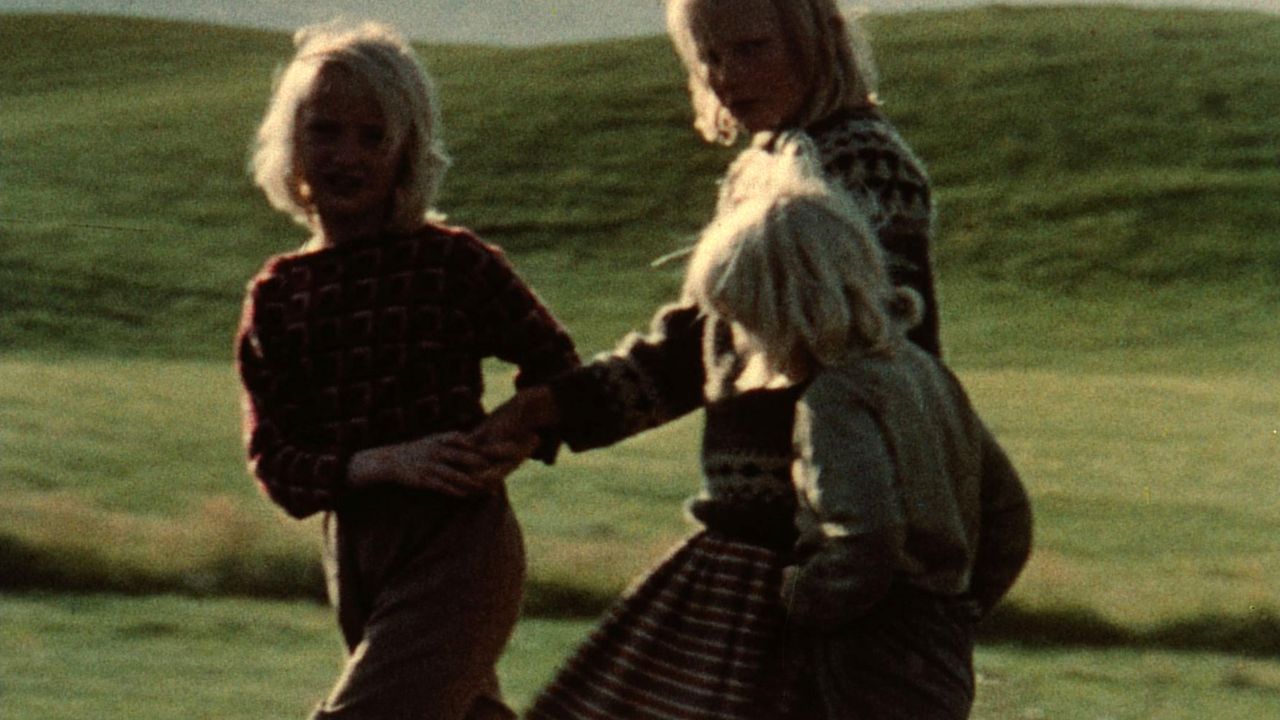 three children standing in a field